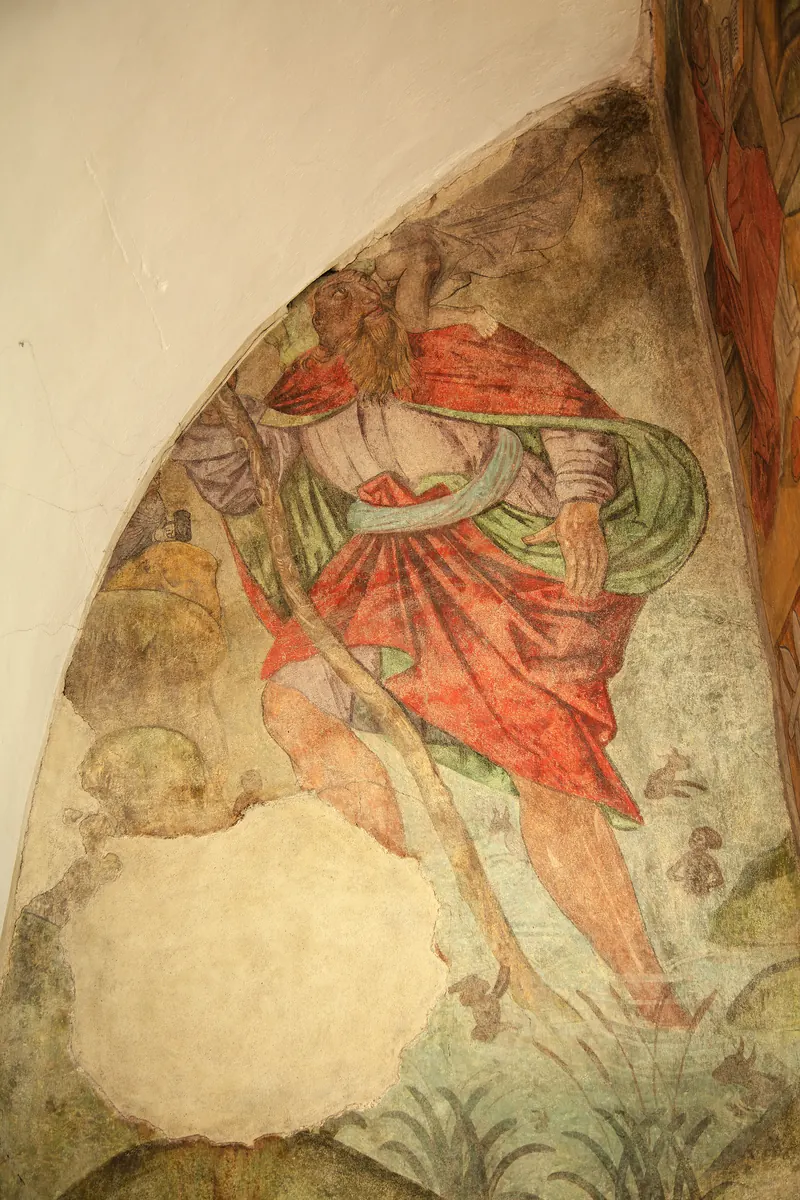 Pittura murale in una nicchia: il gigante Cristoforo con il mantello rosso, sulla spalla Gesù Bambino con un panno svolazzante.