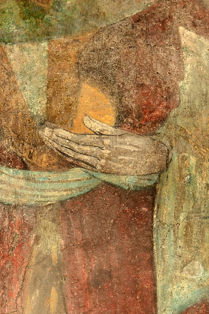 La mano del re in rosso regge il suo vaso.