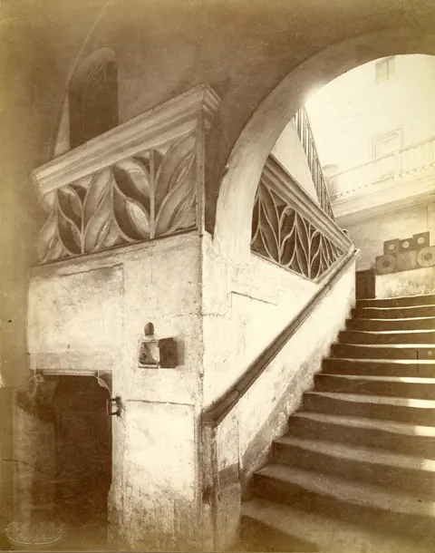 Vecchia foto: la scala con la balaustra in pietra a traforo, a destra un arco a tutto sesto.