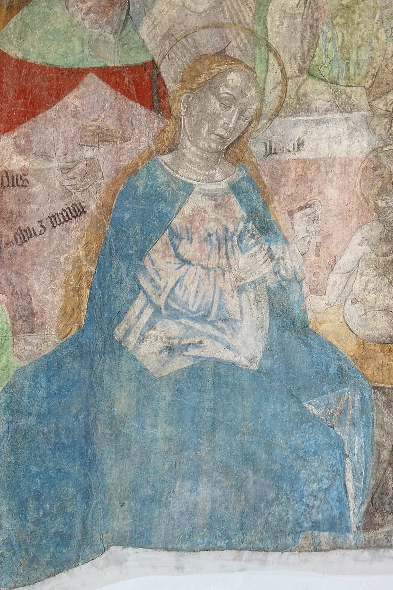 Pittura murale: Maria con un mantello di un blu luminoso e il Bambino, circondata da altre figure della Sacra Parentela.