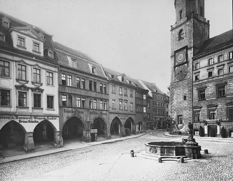 Foto in bianco e nero del 1900 circa: il lato sud dell’Untermarkt con i portici, a destra la torre del municipio.
