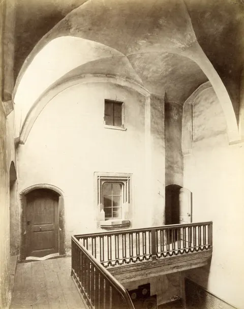 Vecchia foto della sala centrale vuota con galleria e ringhiera in legno.